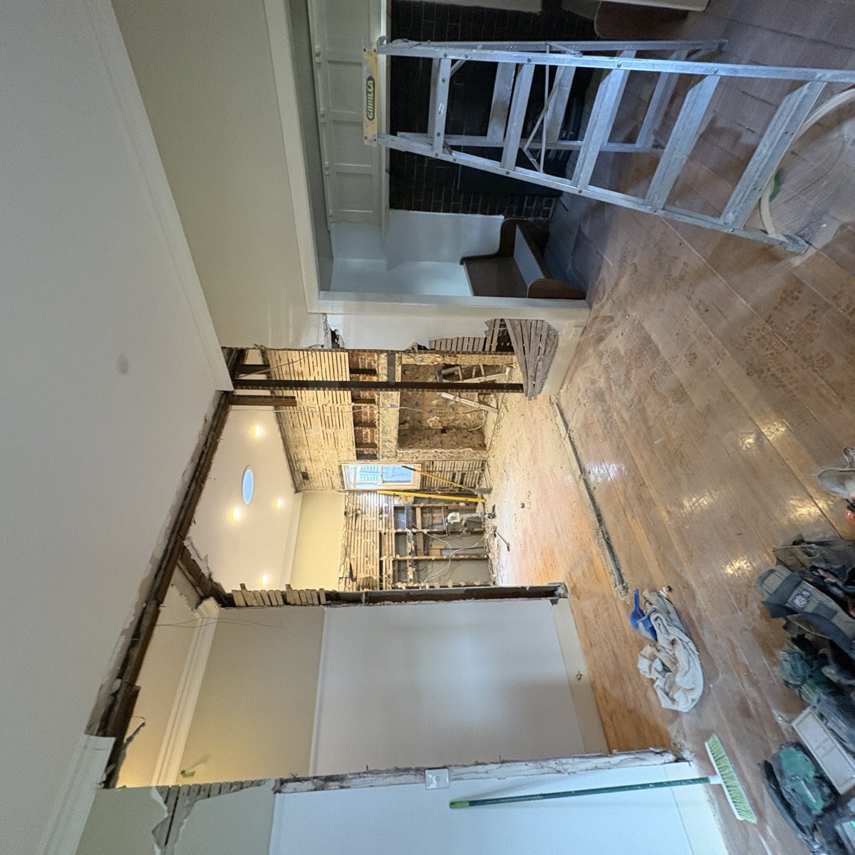 The same room mid-renovation photographed in good light, with the framing, brickwork and finishes all clearly visible