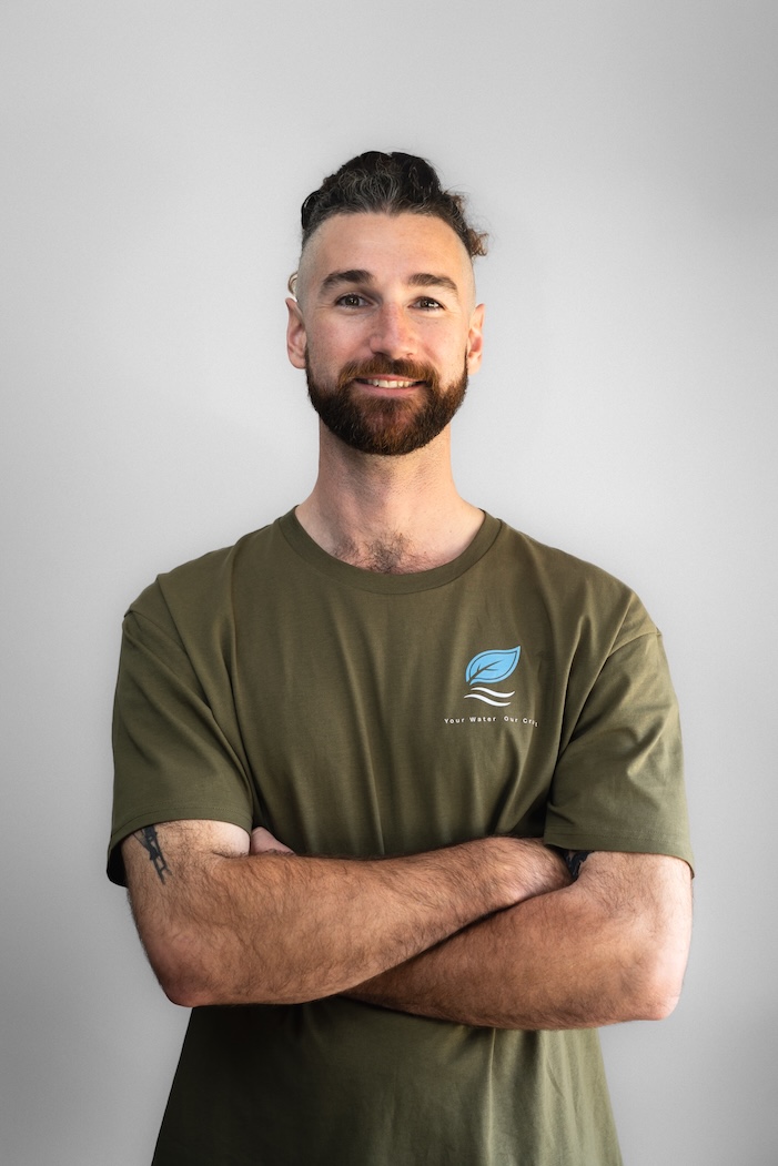 Plumbing business owner in a branded work shirt